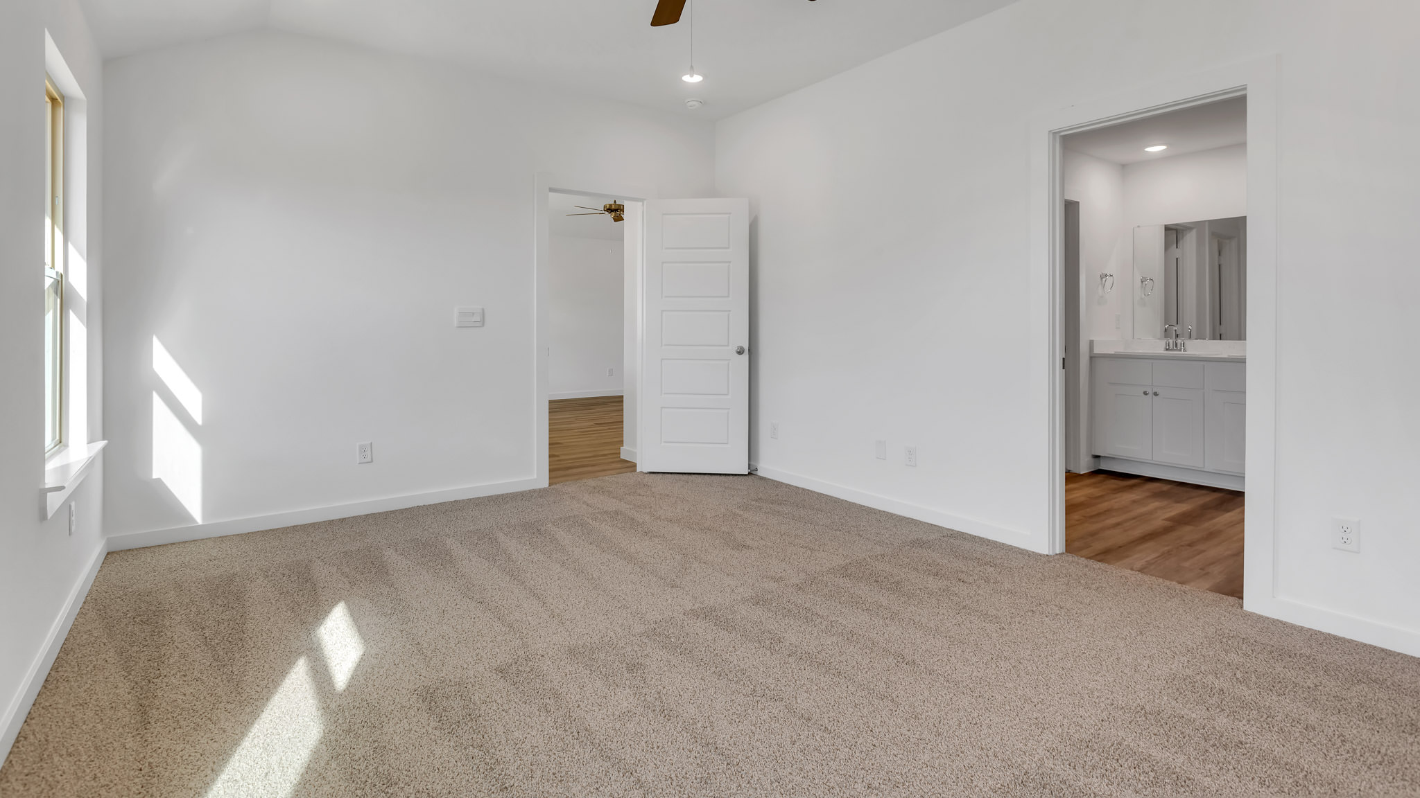 Primary room with attached walk in closet and private bathroom