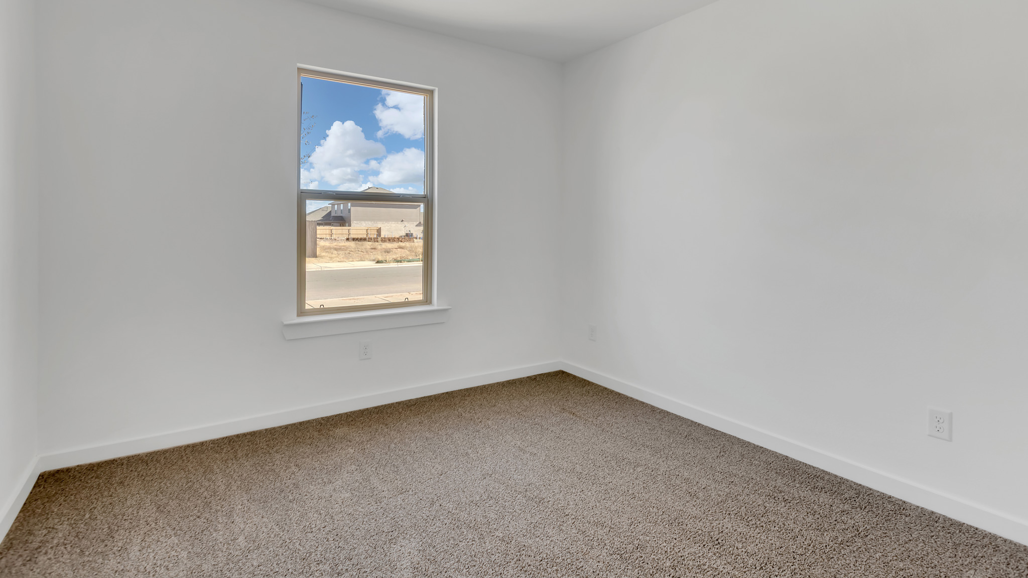Bedroom 1 with front window and plush carpet floors