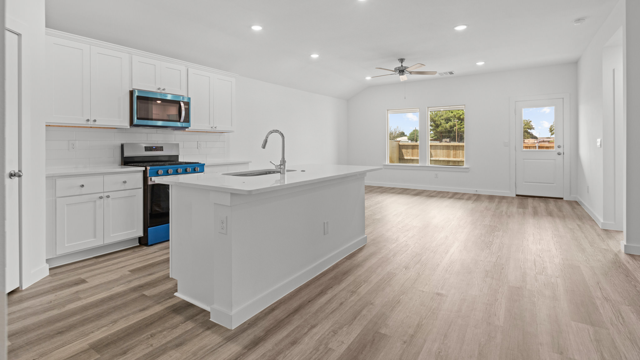 kitchen with spacious island, quartz counters and stainless-steel appliances
