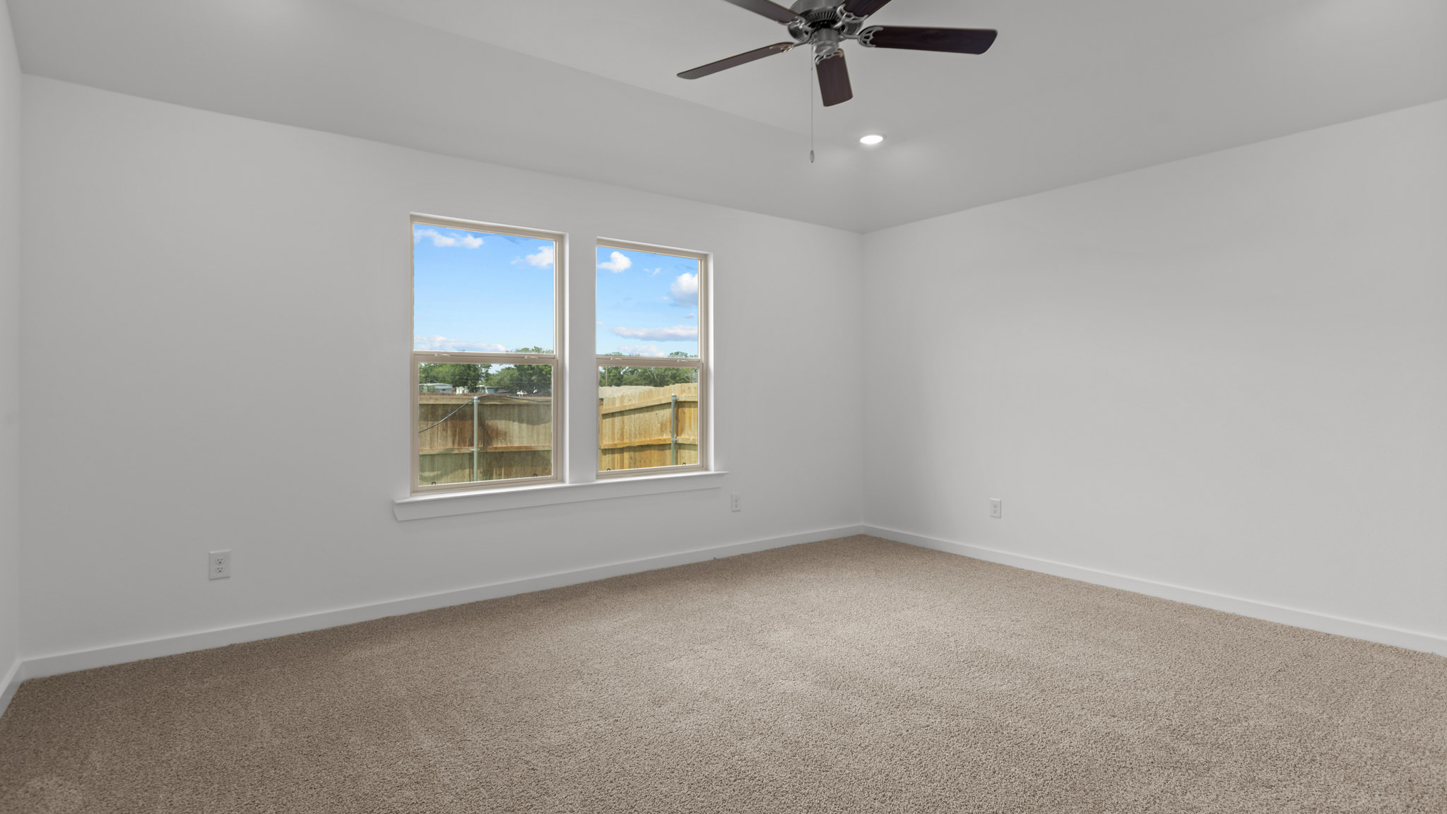 primary bedroom with plush carpet and windows overlooking the backyard