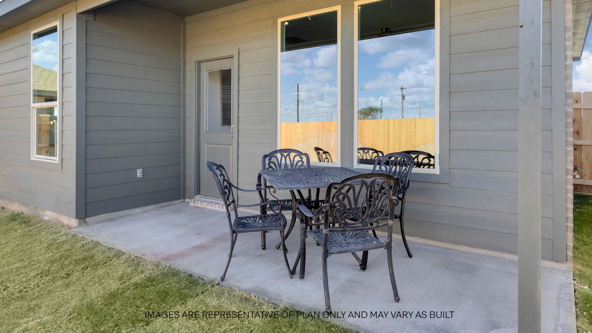 Covered back patio area overlooking spacious backyard
