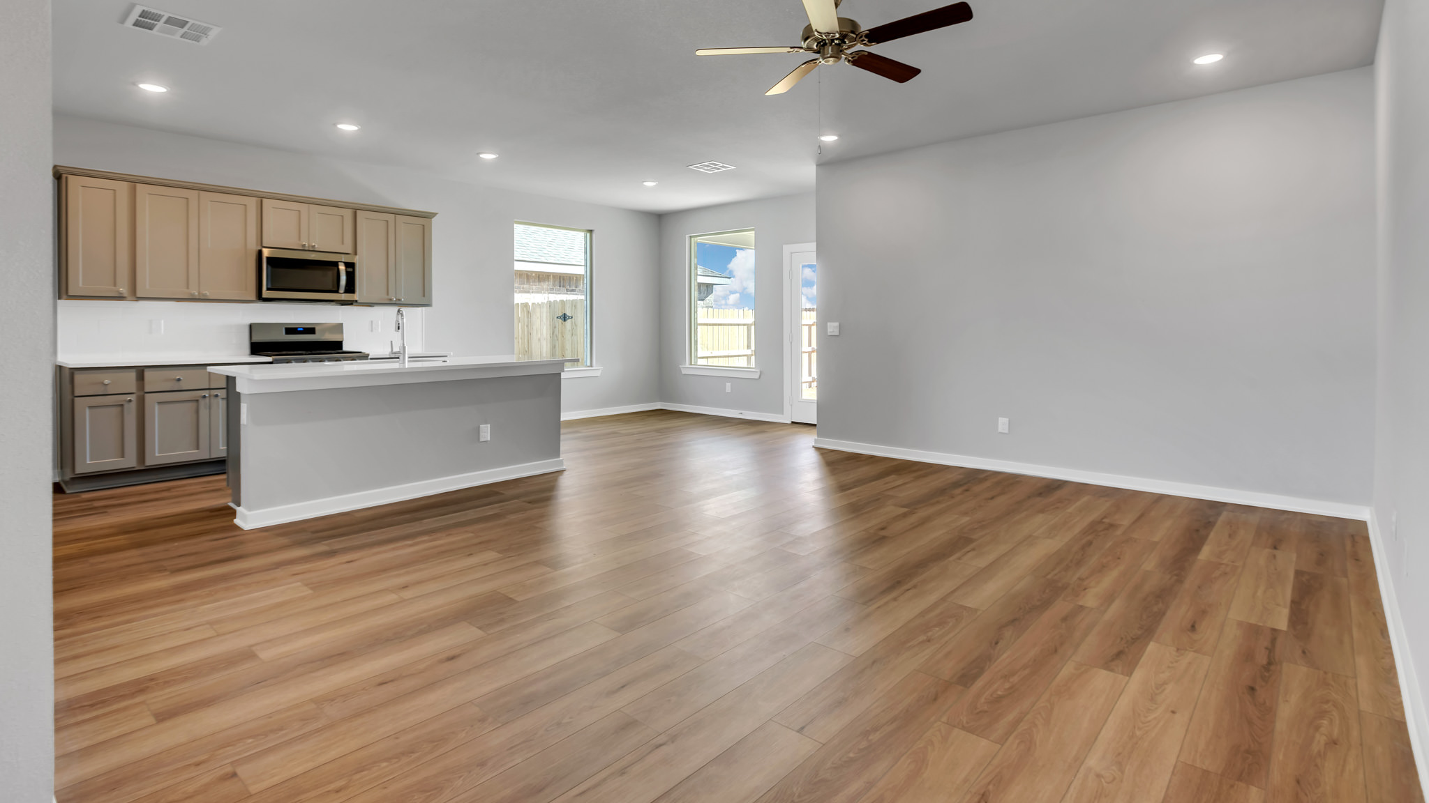 Open concept kitchen, living and dining area with ample lighting