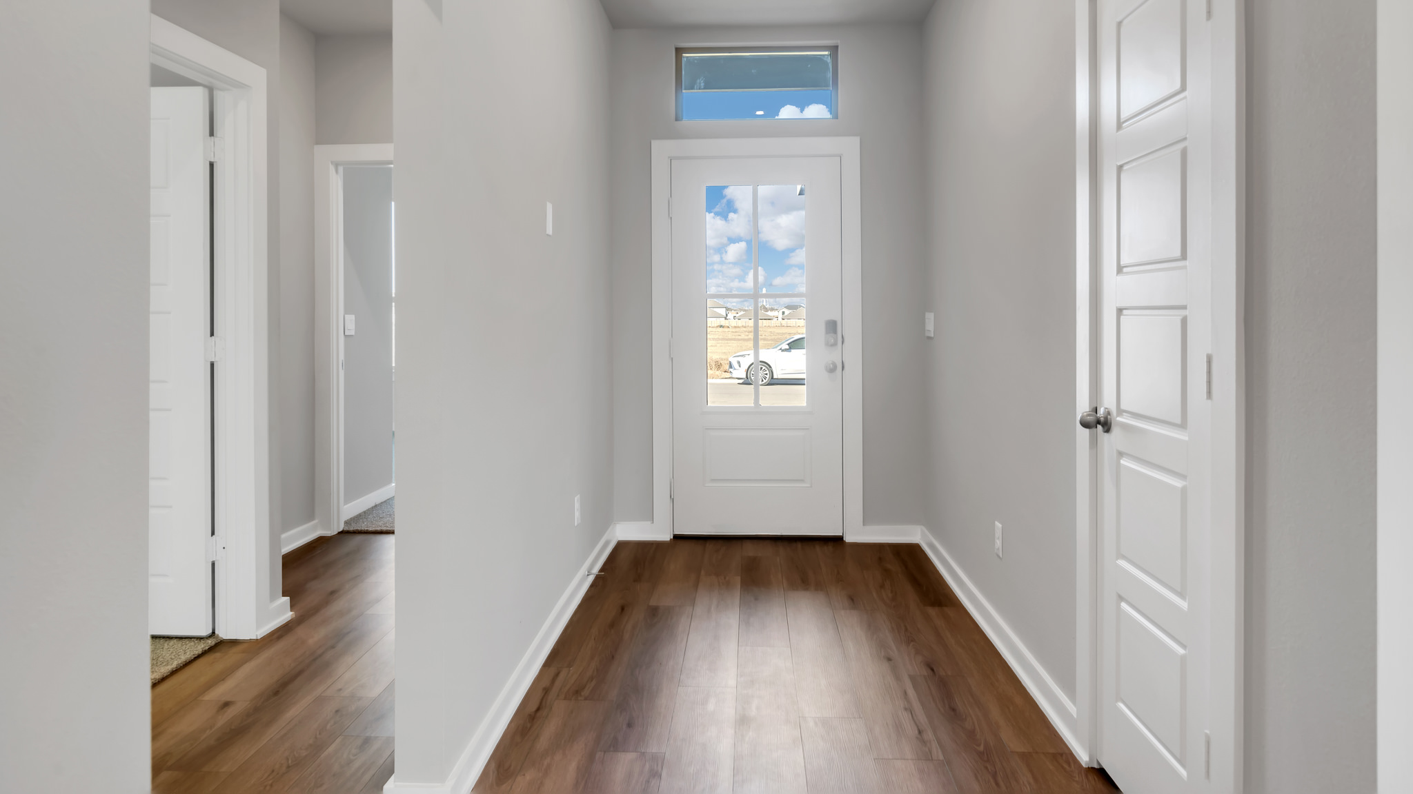 Foyer entrance with bedrooms on the side and garage entrance