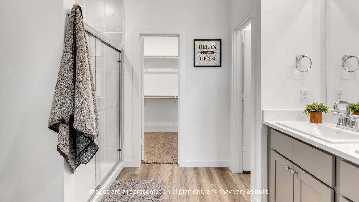 Private attached primary bathroom with built in vanity and luxurious shower