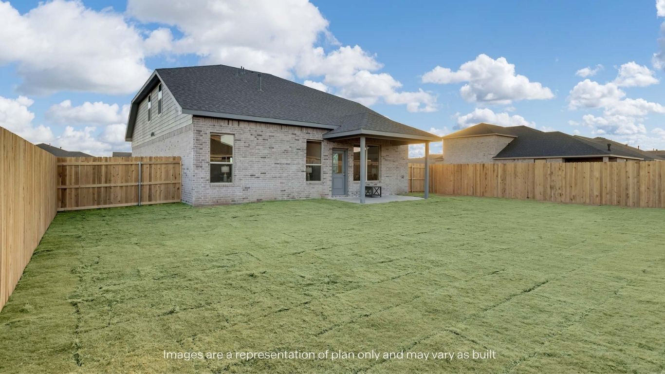 Covered back patio area overlooking spacious backyard