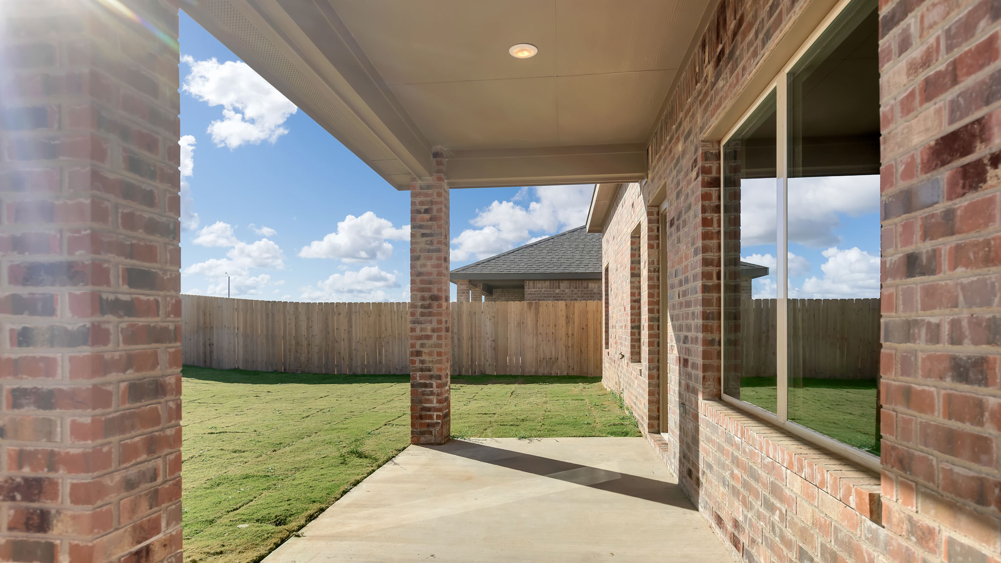 Covered back patio area overlooking spacious backyard