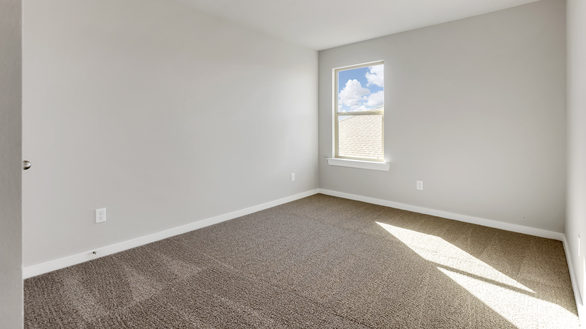 Upstairs Guest bedroom with plush carpet and side window