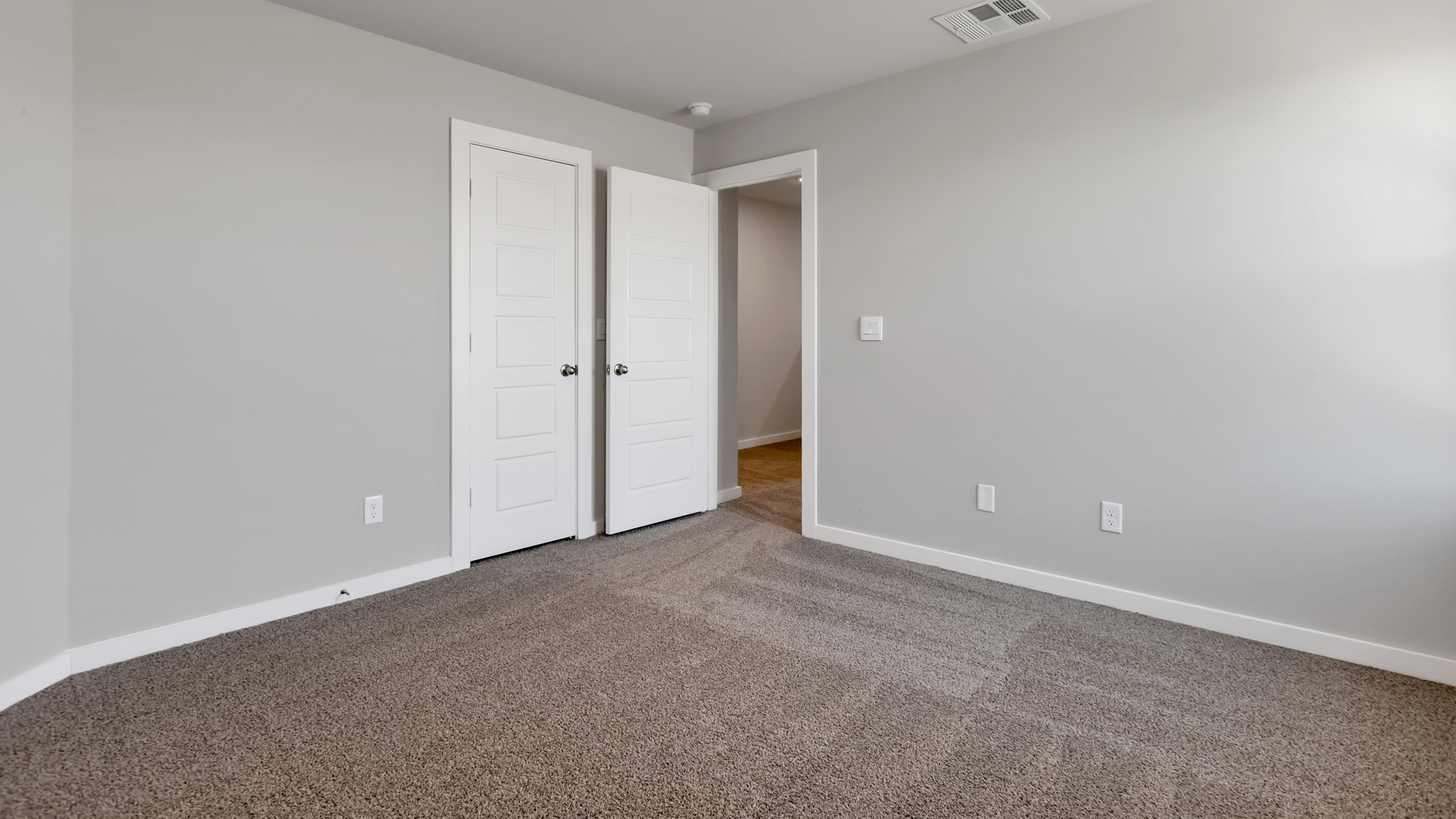 Upstairs Guest bedroom with plush carpet floors and spacious closet