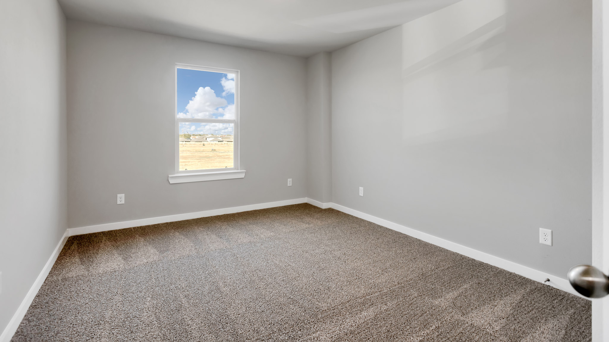 Upstairs Guest bedroom with plush carpet and side window