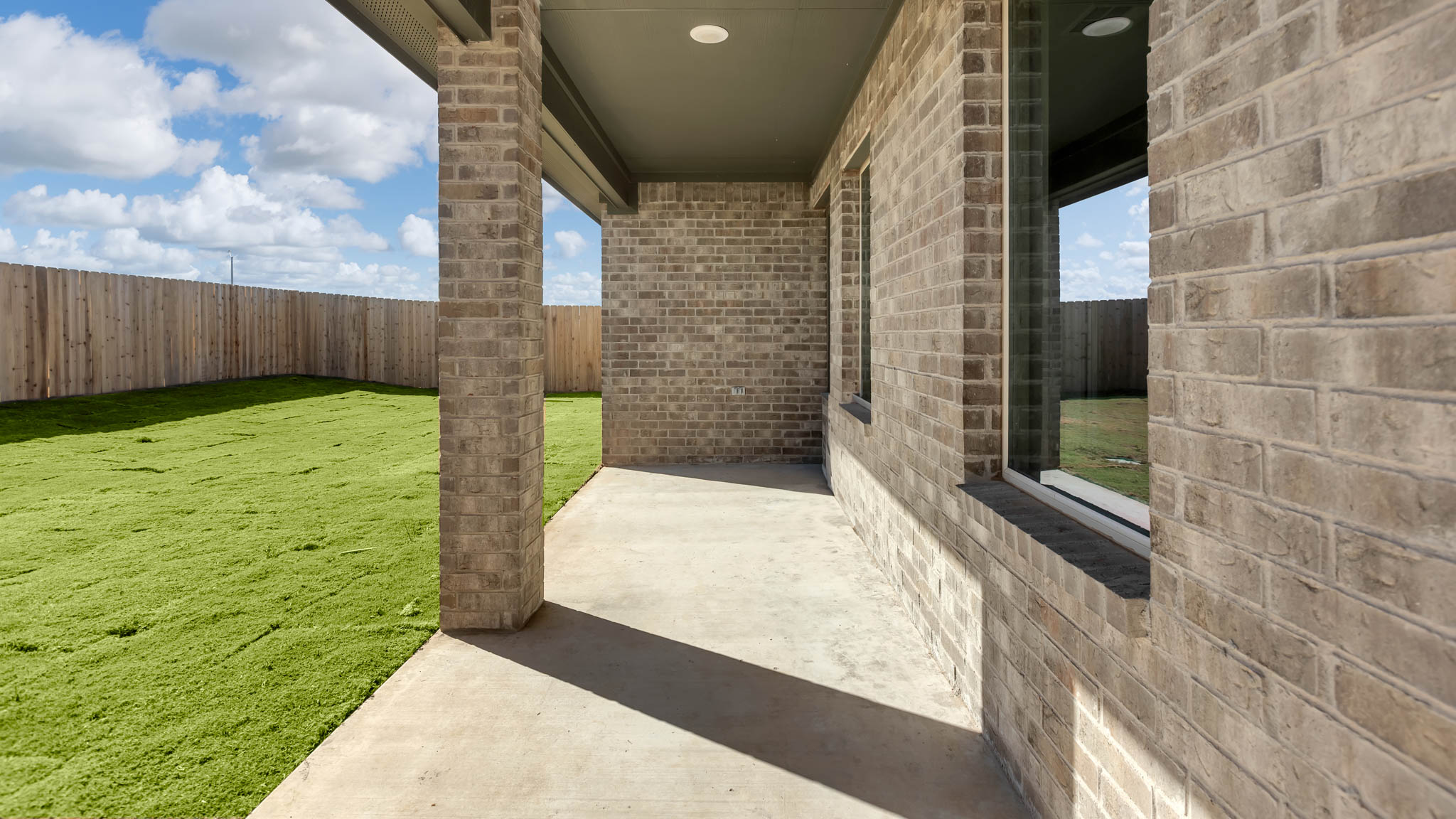 Covered back patio area overlooking spacious backyard