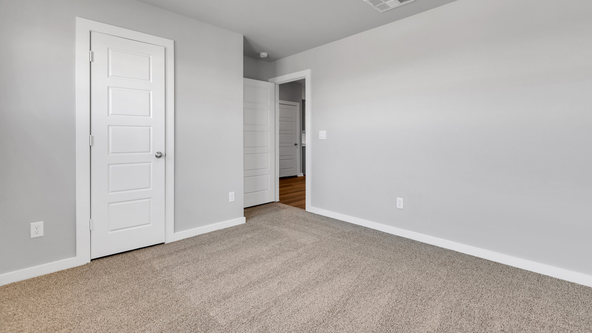 Guest bedroom 1 with plush carpet and spacious closet