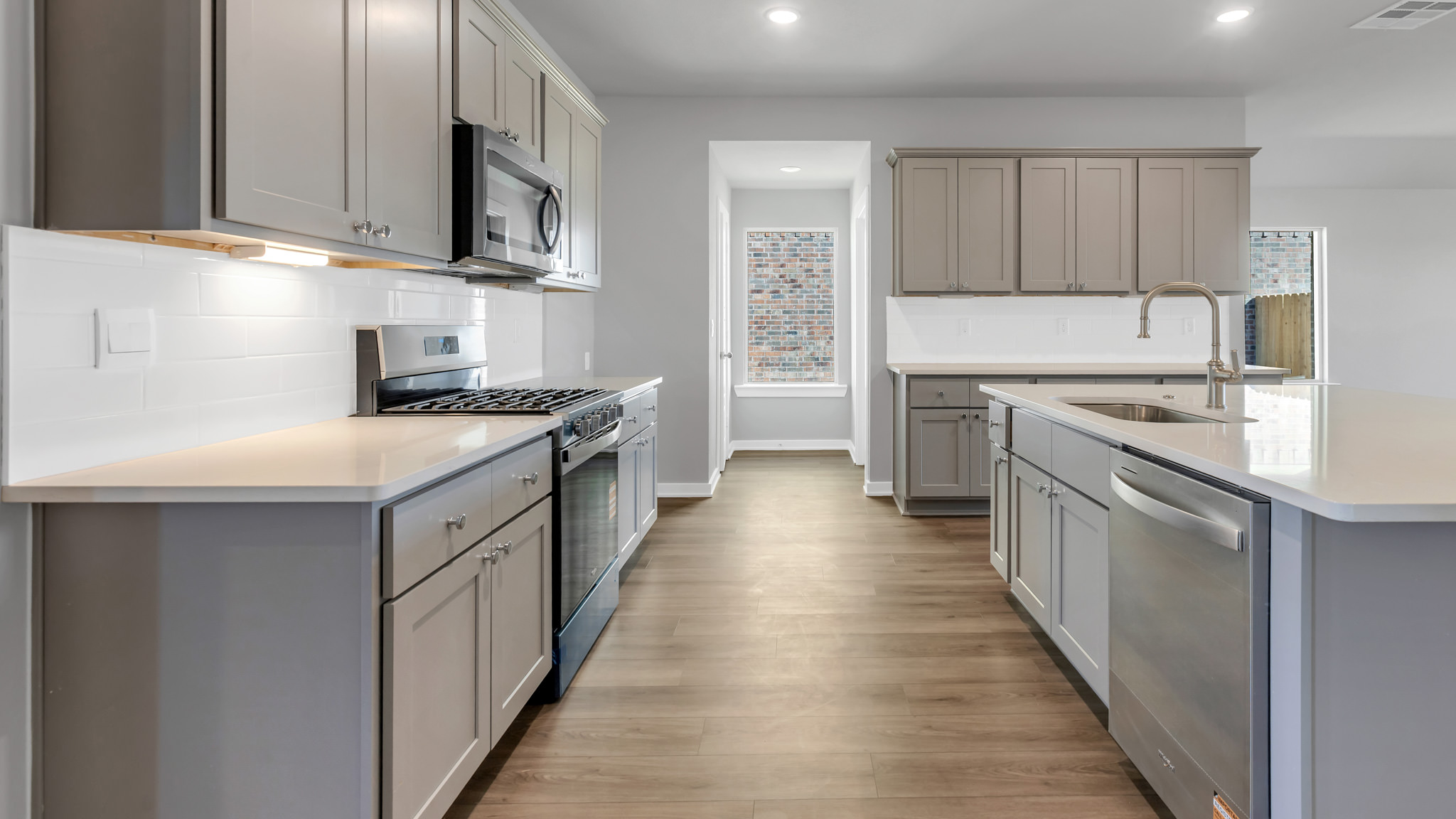 Open concept kitchen with stainless steel appliances, shaker style cabinets, and elevated finishes