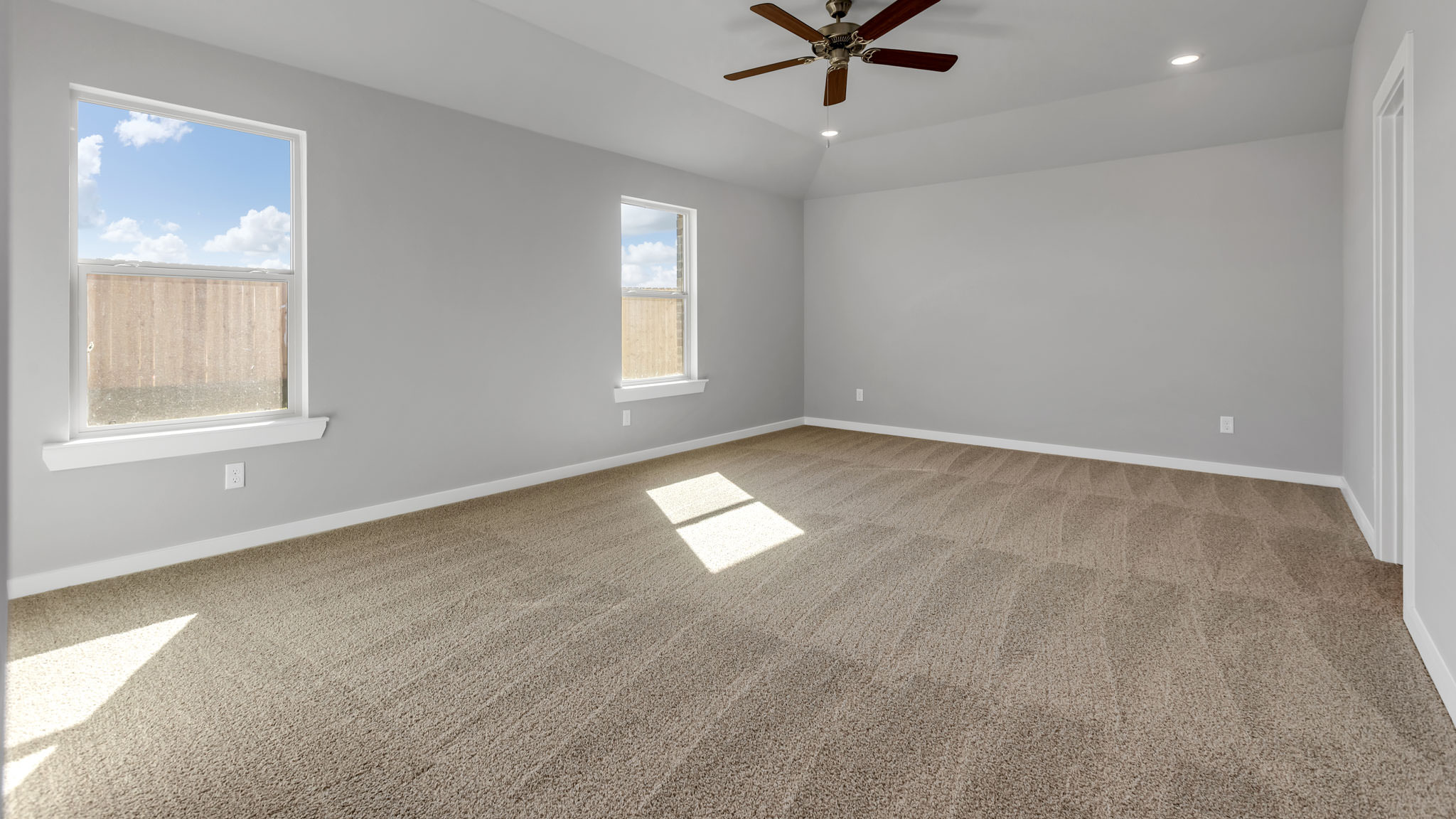 Primary bedroom with plush carpet floors and light allowing double windows
