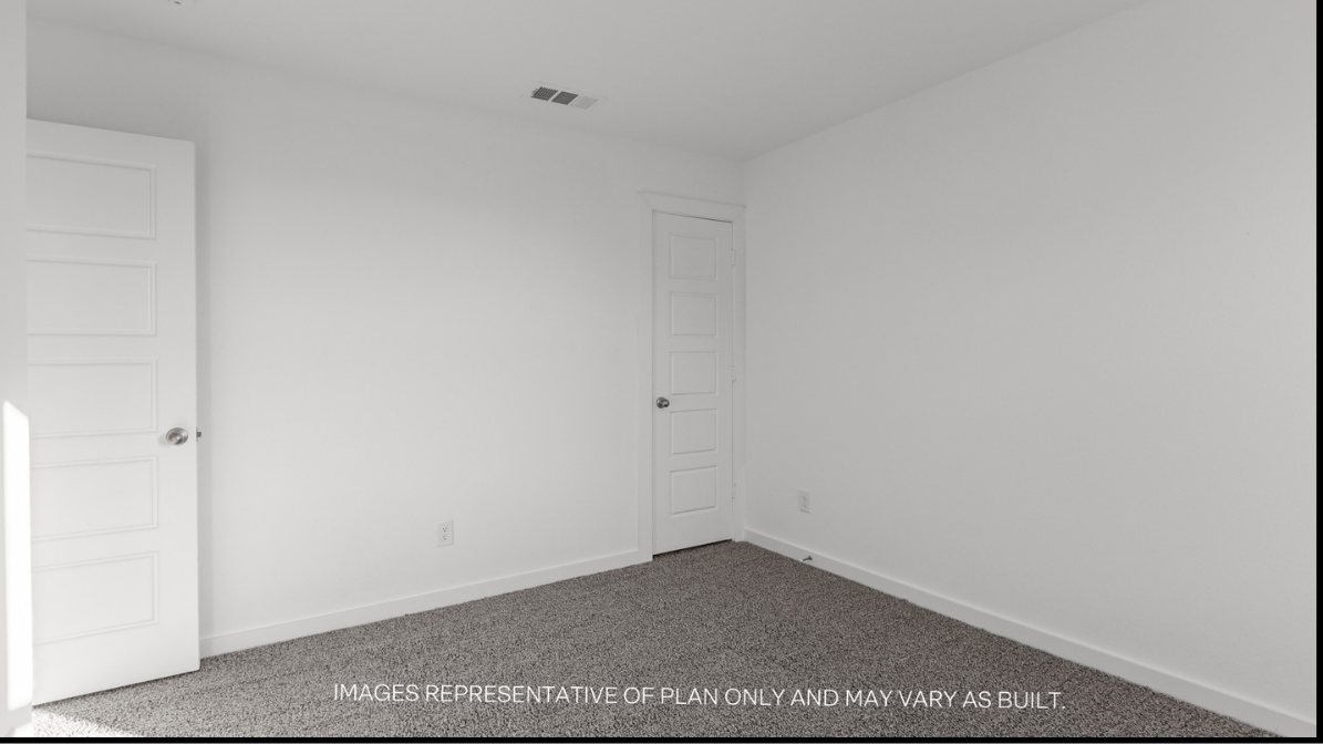 Guest bedroom with plush carpet floors and spacious closet