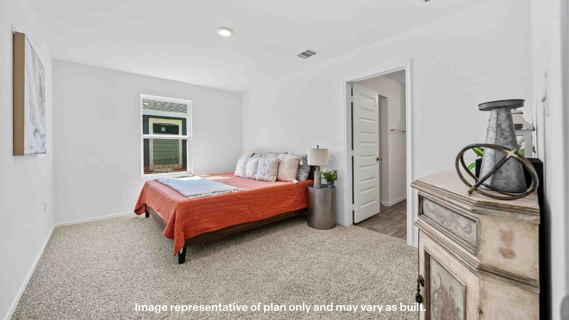 Primary bedroom with plush carpet floors and ample light