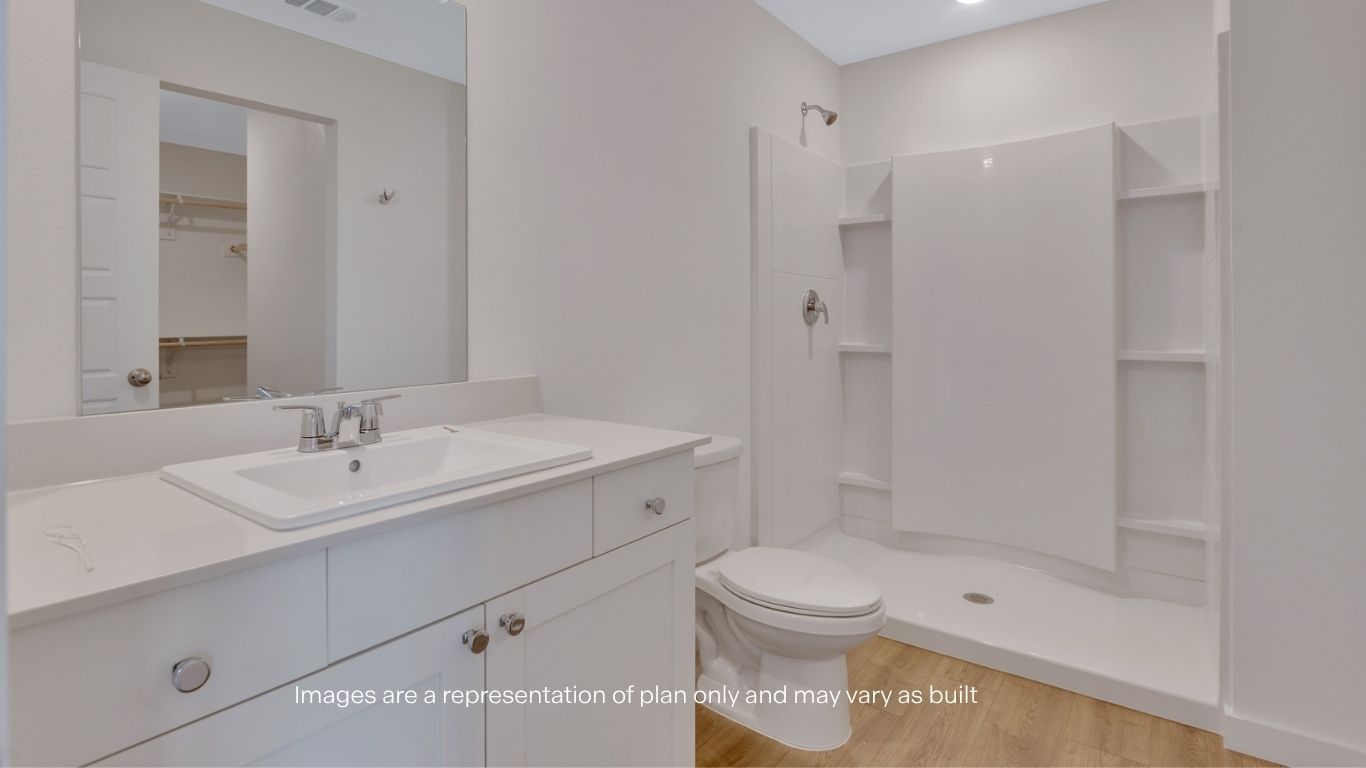 Private attached primary bathroom with built in vanity and luxurious shower