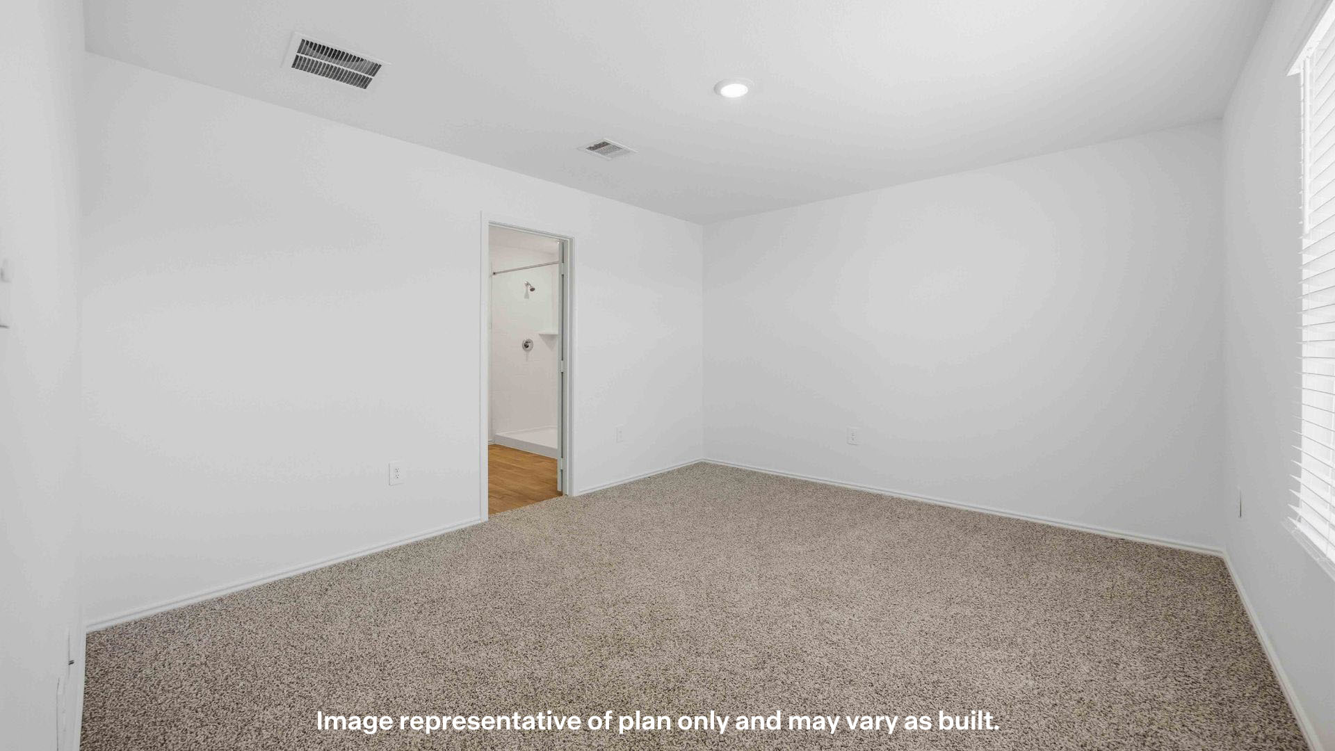 Primary bedroom with plush carpet floors and ample natural light