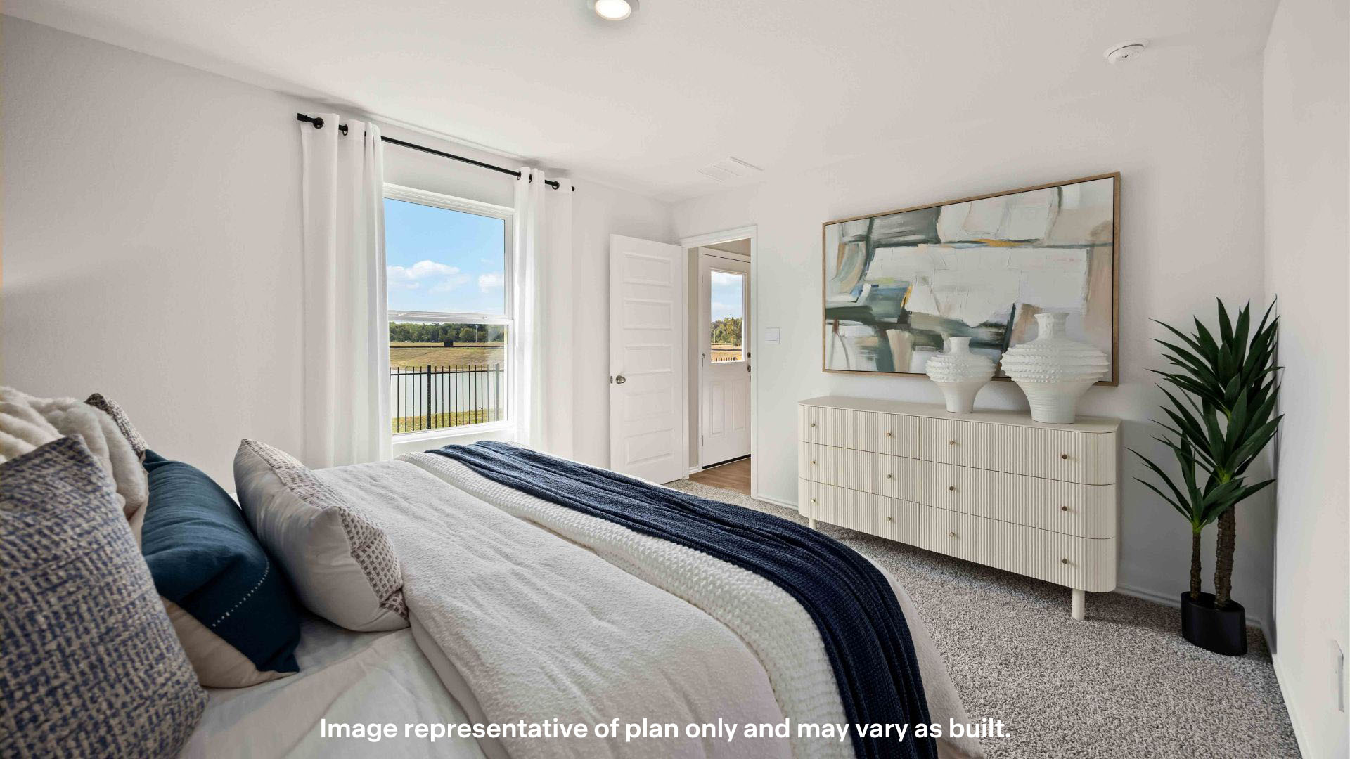 Primary bedroom with ample light and plush carpet floors