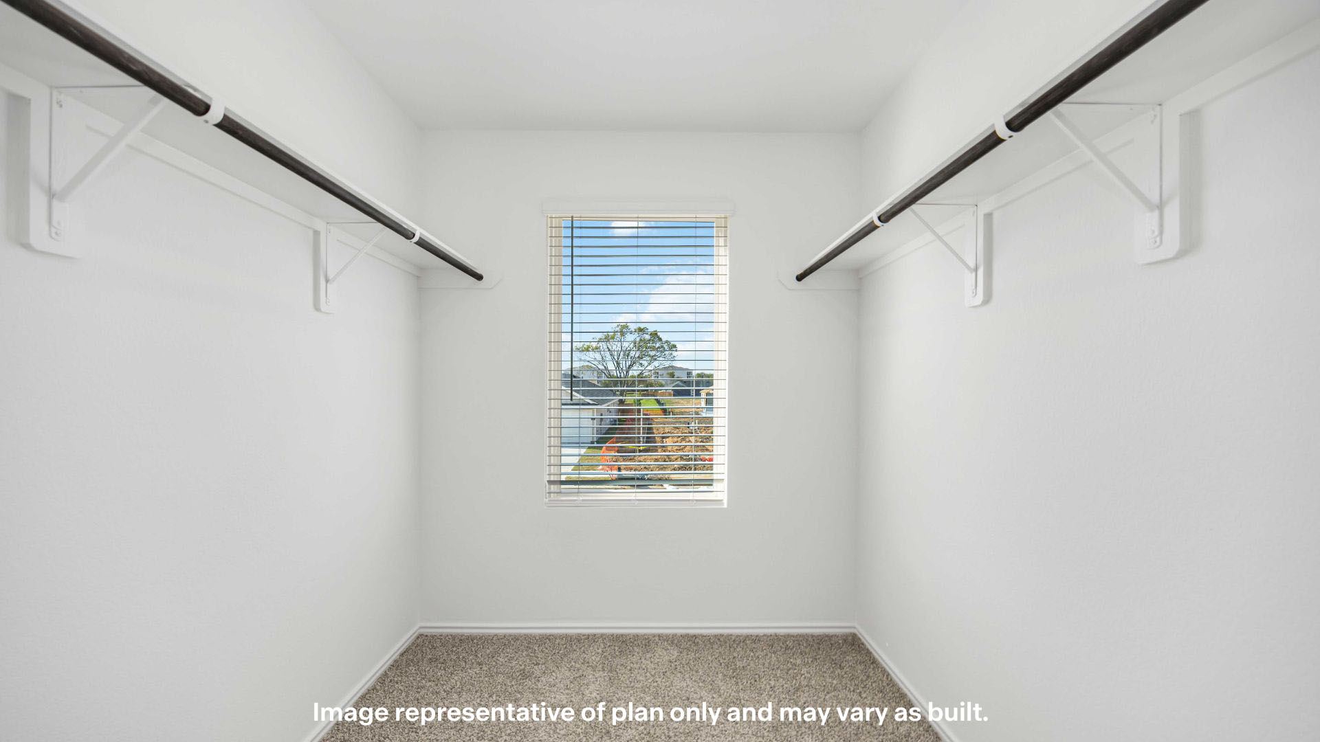 Primary walk-in closet with front window and extra storage space