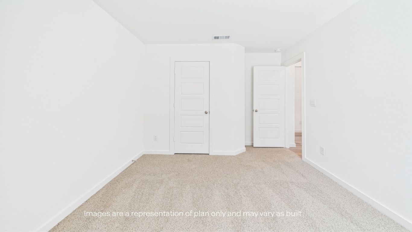 Guest bedroom with plush carpet and spacious closet