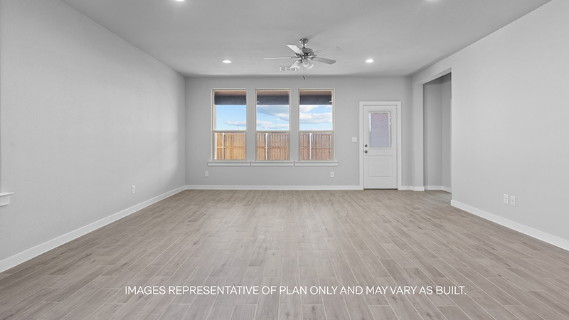 open airy living area with windows overlooking backyard