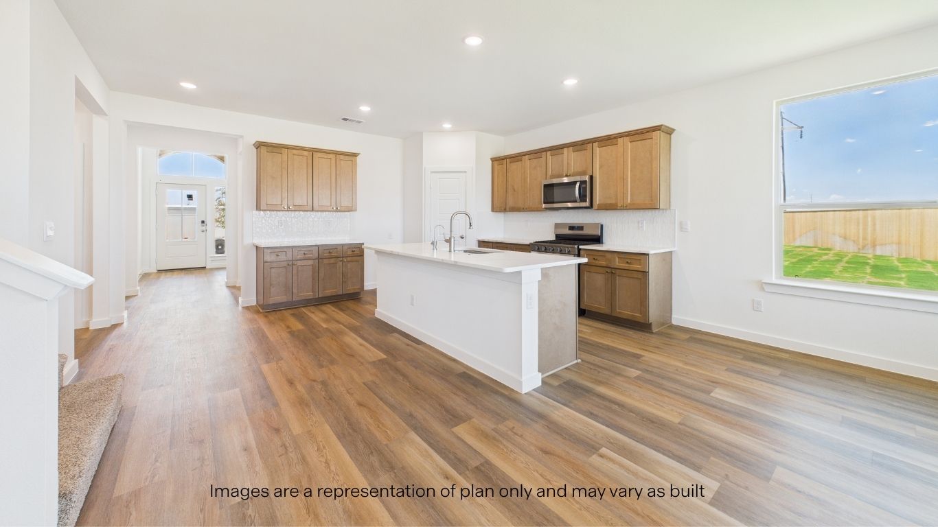 Open concept kitchen with stainless steel appliances, shaker style cabinets, and elevated finishes