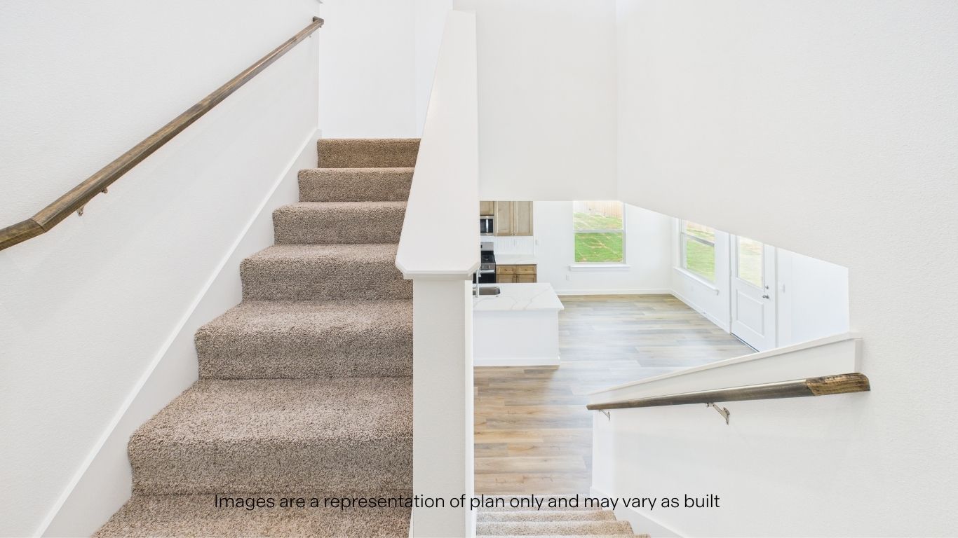 Carpeted staircase with wood tone handrails