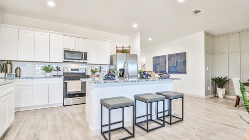 Kitchen peninsula with white cabinets and stainless steel appliances