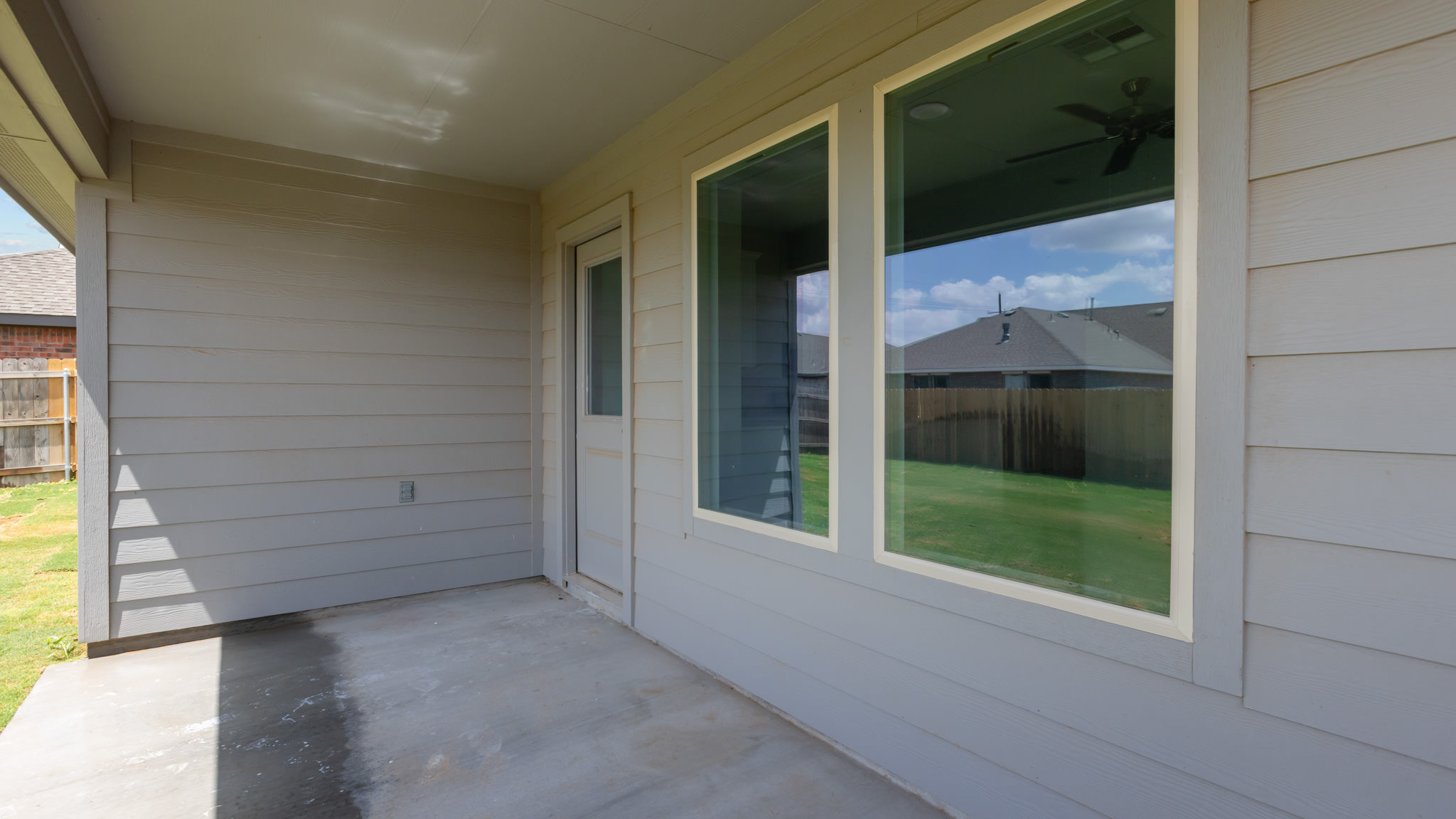 Covered back patio area overlooking spacious backyard