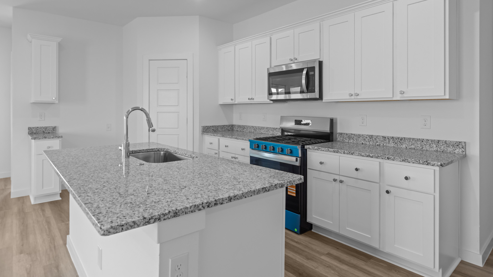 Open concept kitchen with stainless steel appliances, shaker style cabinets, and elevated finishes