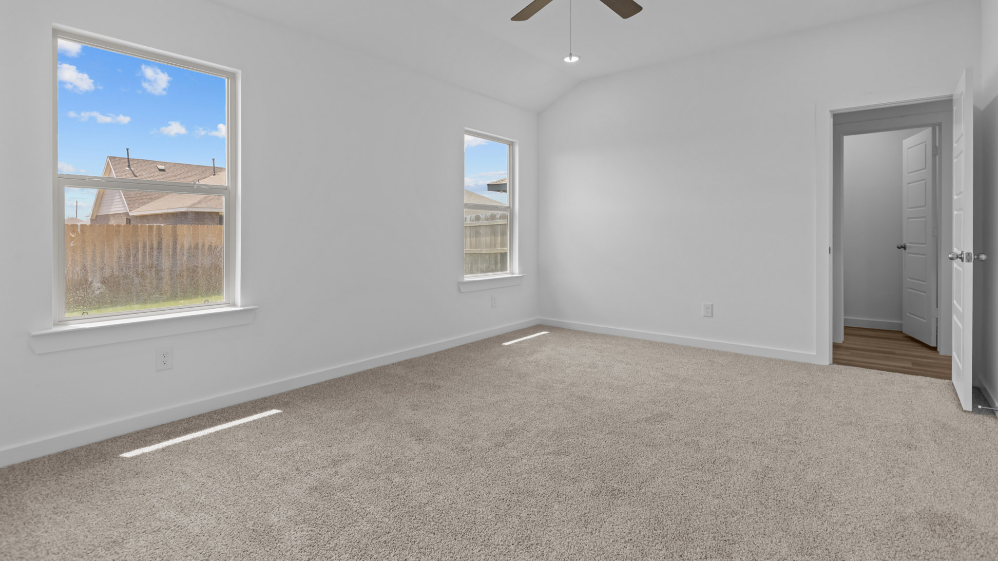 Primary bedroom with plush carpet floors and light allowing double windows