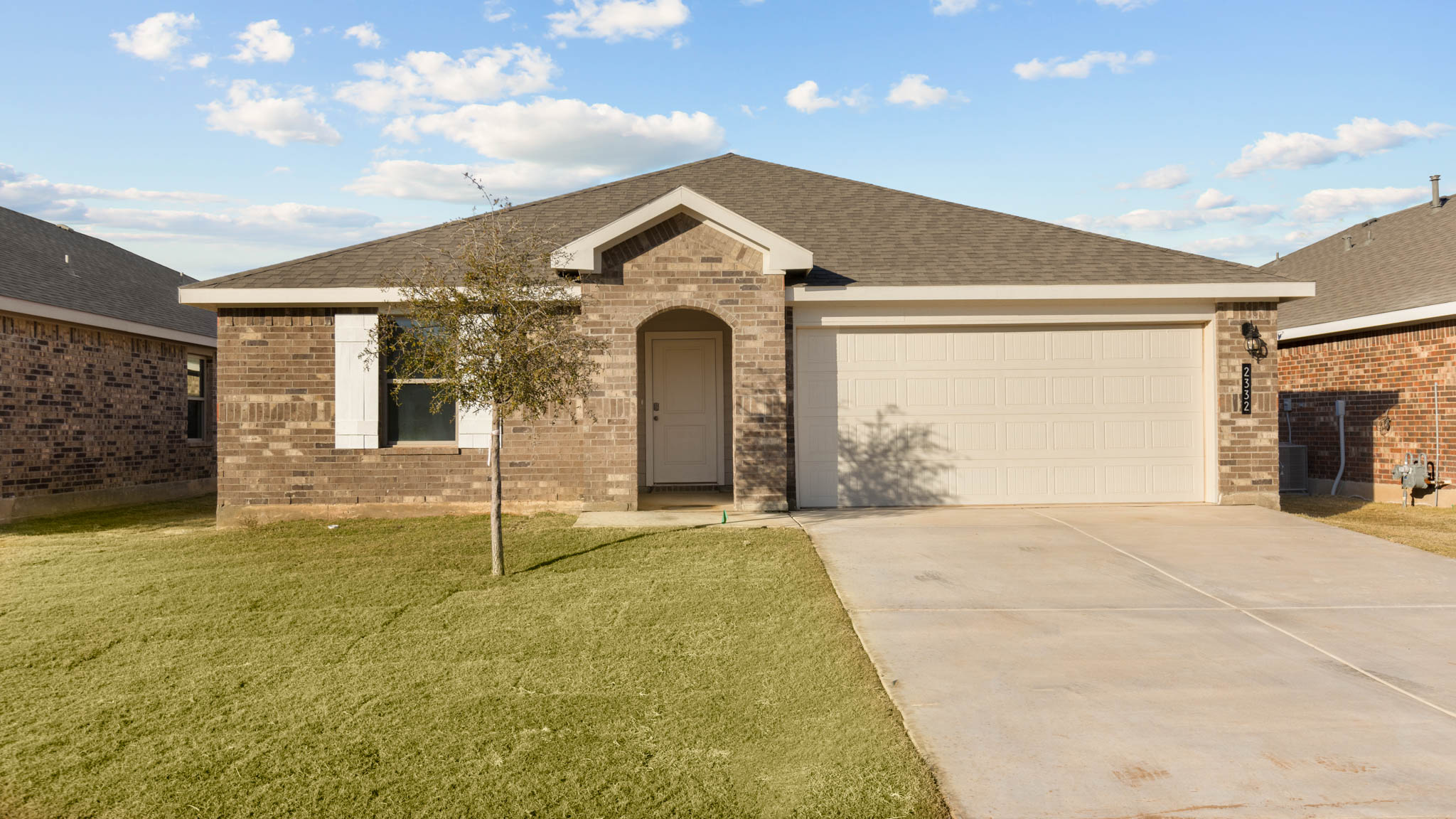 Single- story home with brick, covered patio and two car garage