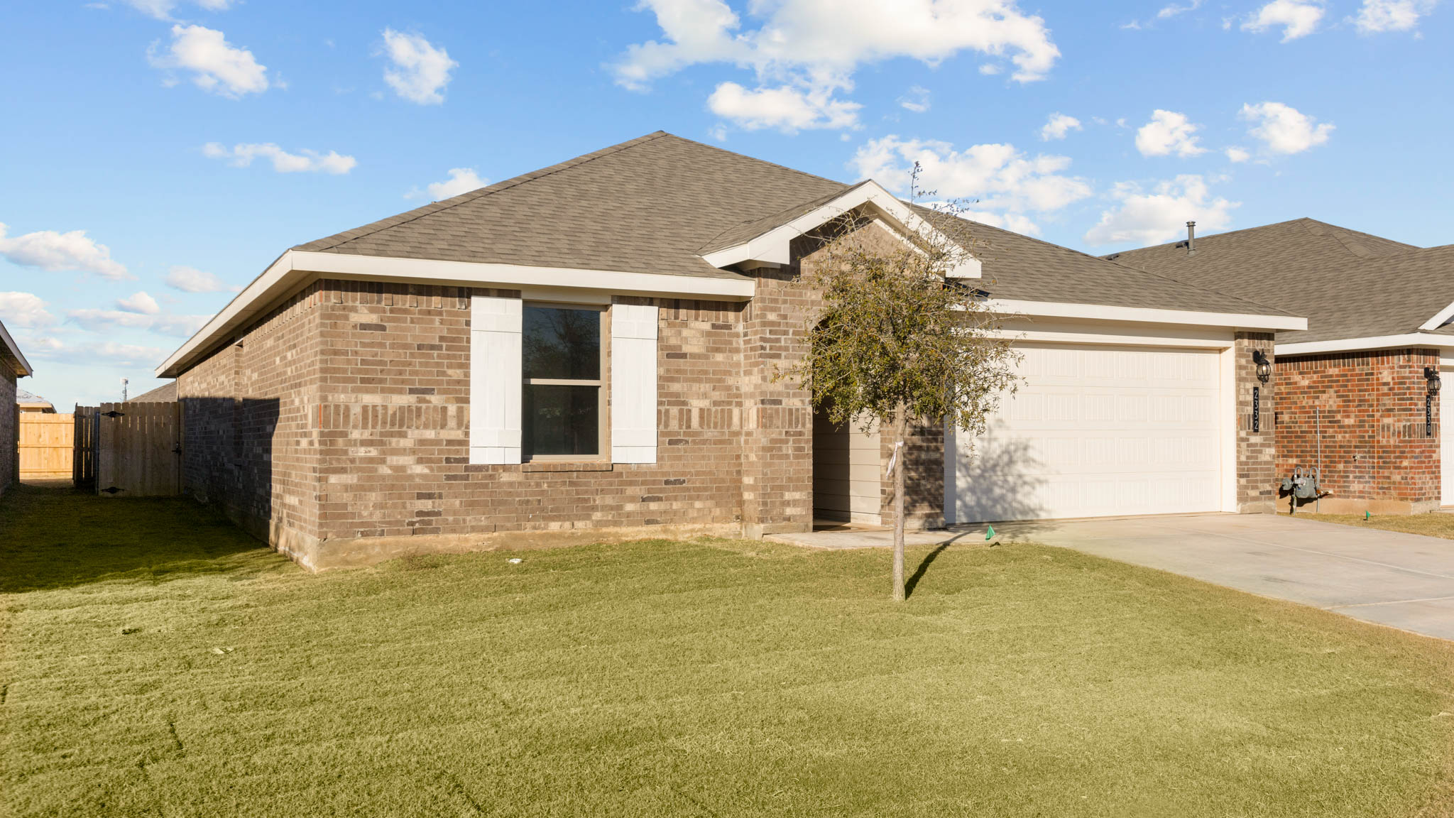 Single- story home with brick, covered patio and two car garage