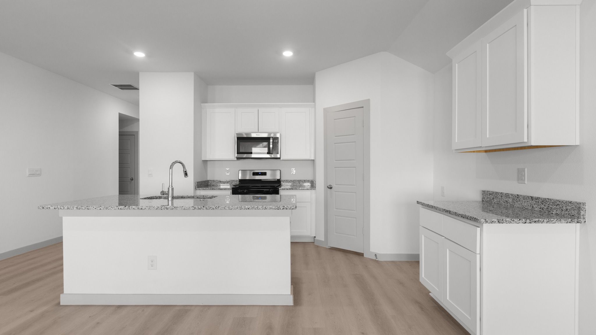Kitchen with spacious island, white cabinets and white interior