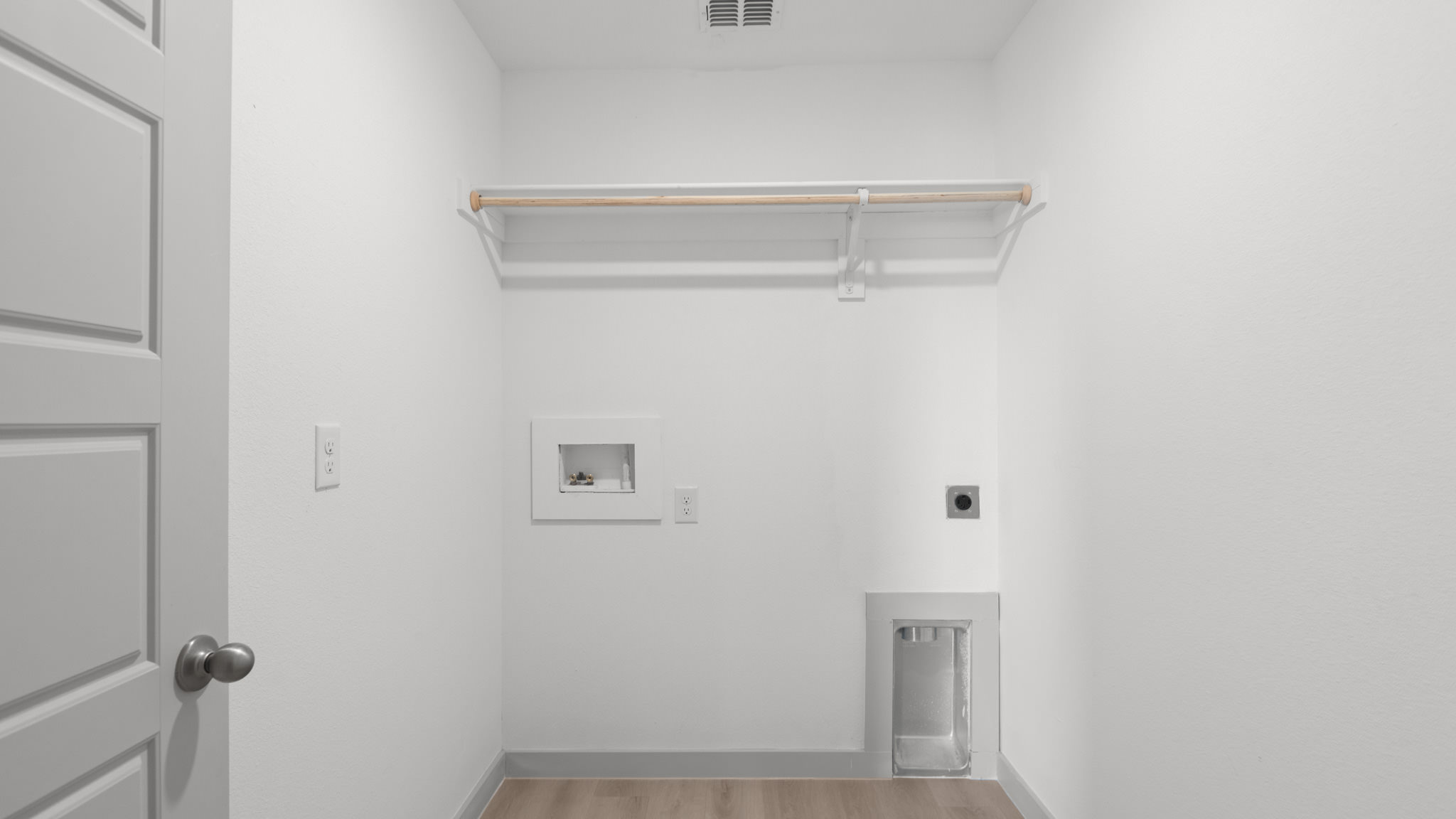 Laundry and utility room with wooden shelving just off the entry way