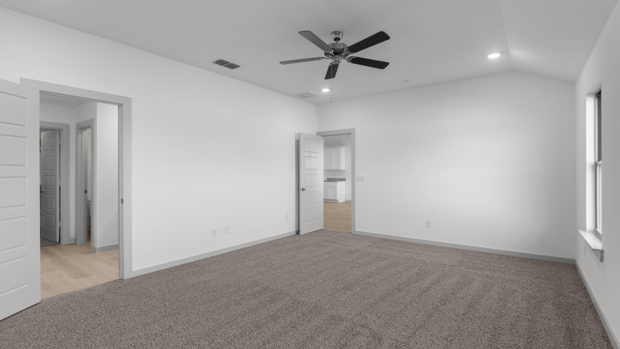 Primary bedroom with plush carpet and attached bathroom