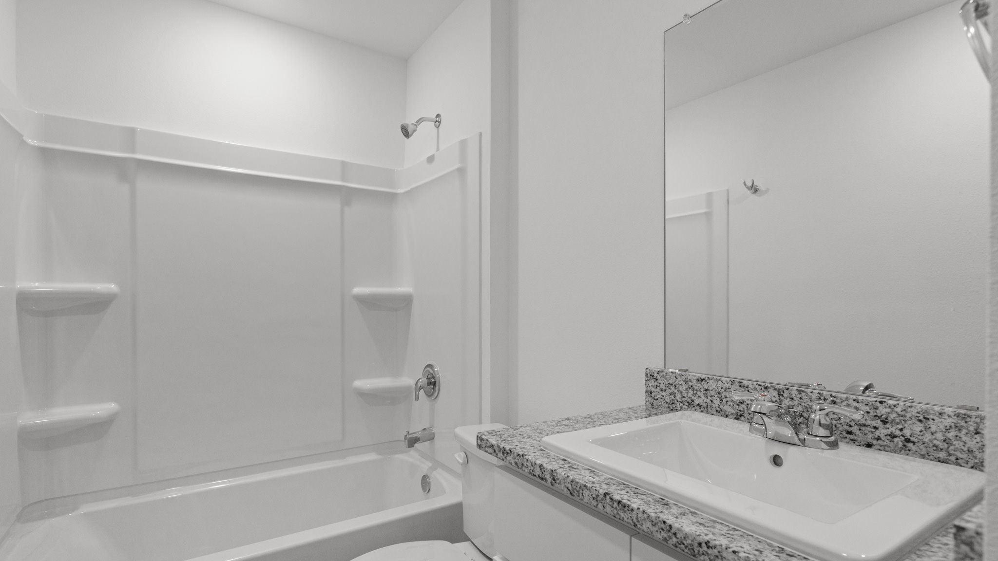 Guest bathroom with single sink, vanity and bathtub shower combo