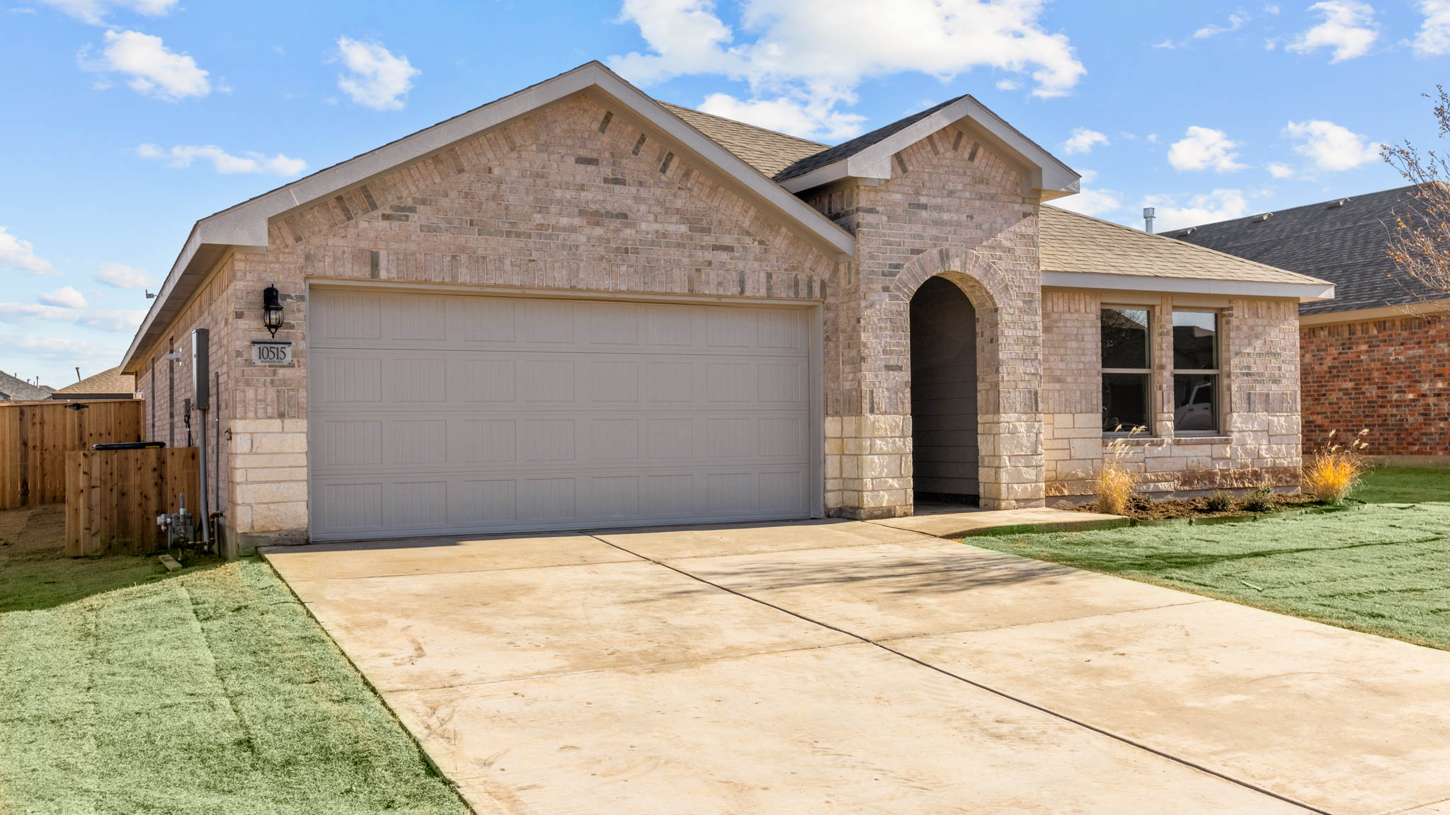 Single- story home with brick, stone, covered patio and two car garage