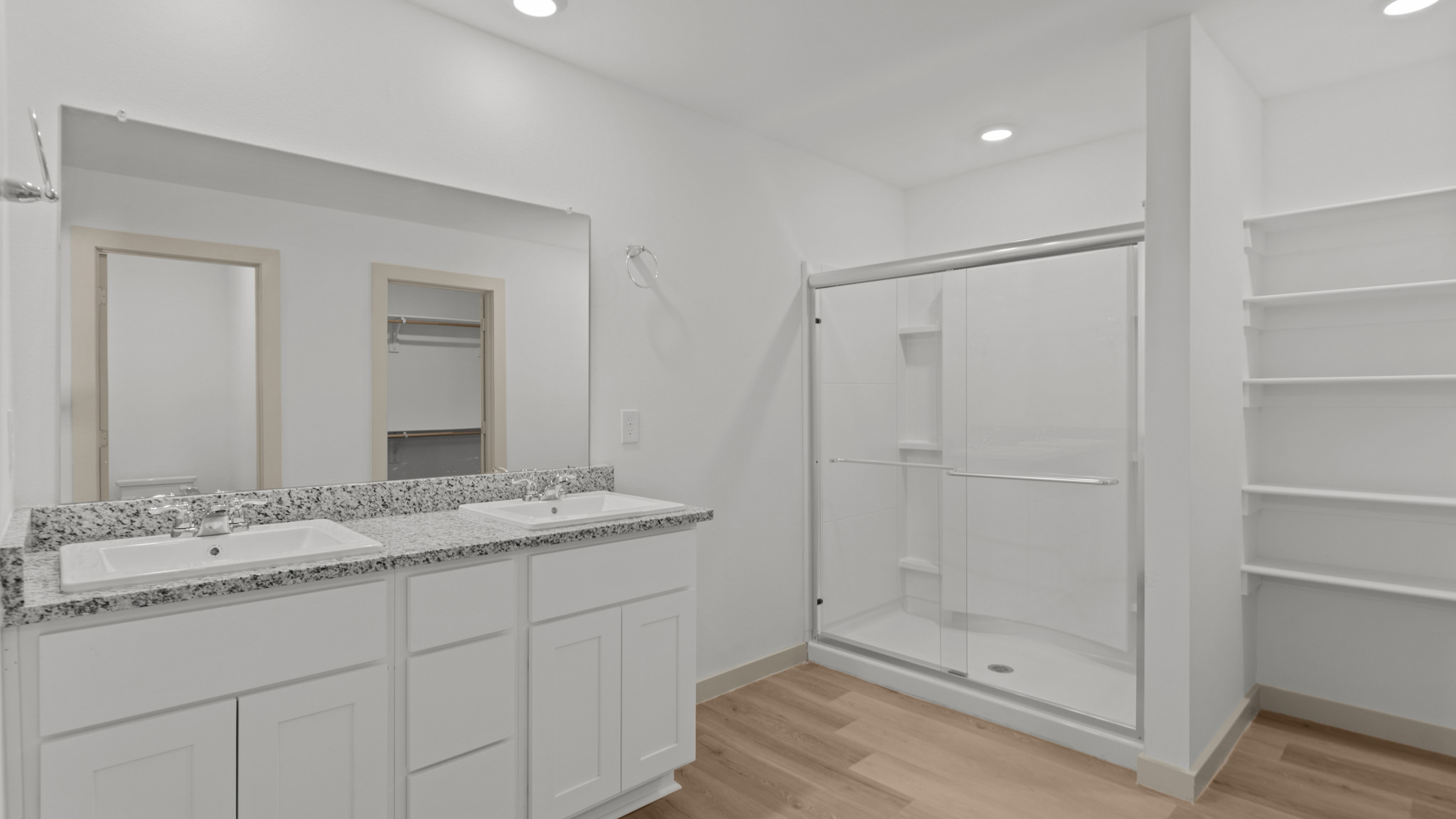 Primary bathroom with dual sink, vanity, and walk in shower