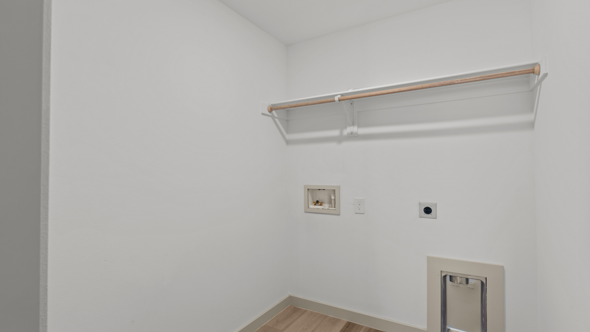 Laundry and utility room with wooden shelving just off the entry way