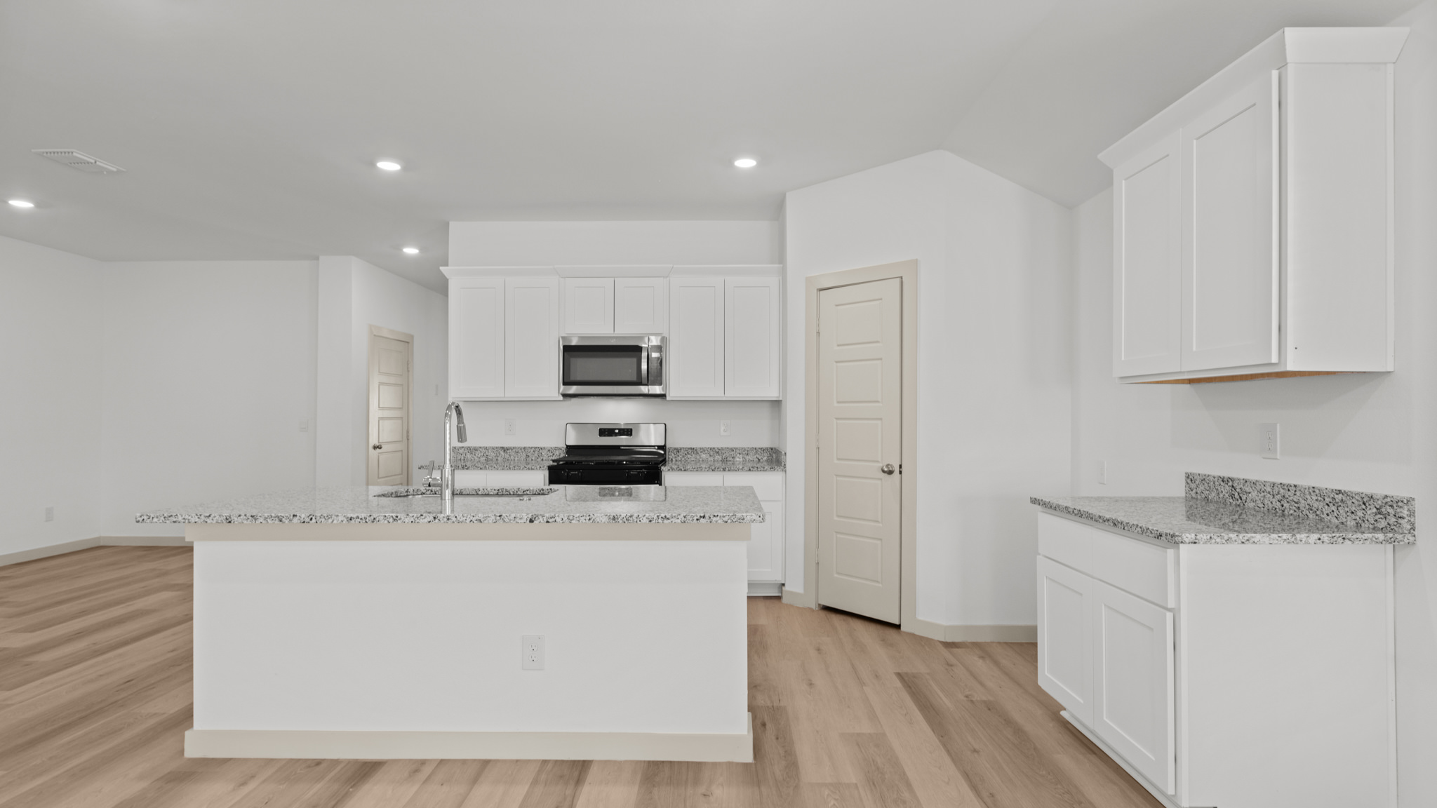 Kitchen with spacious island, pantry and white cabinets