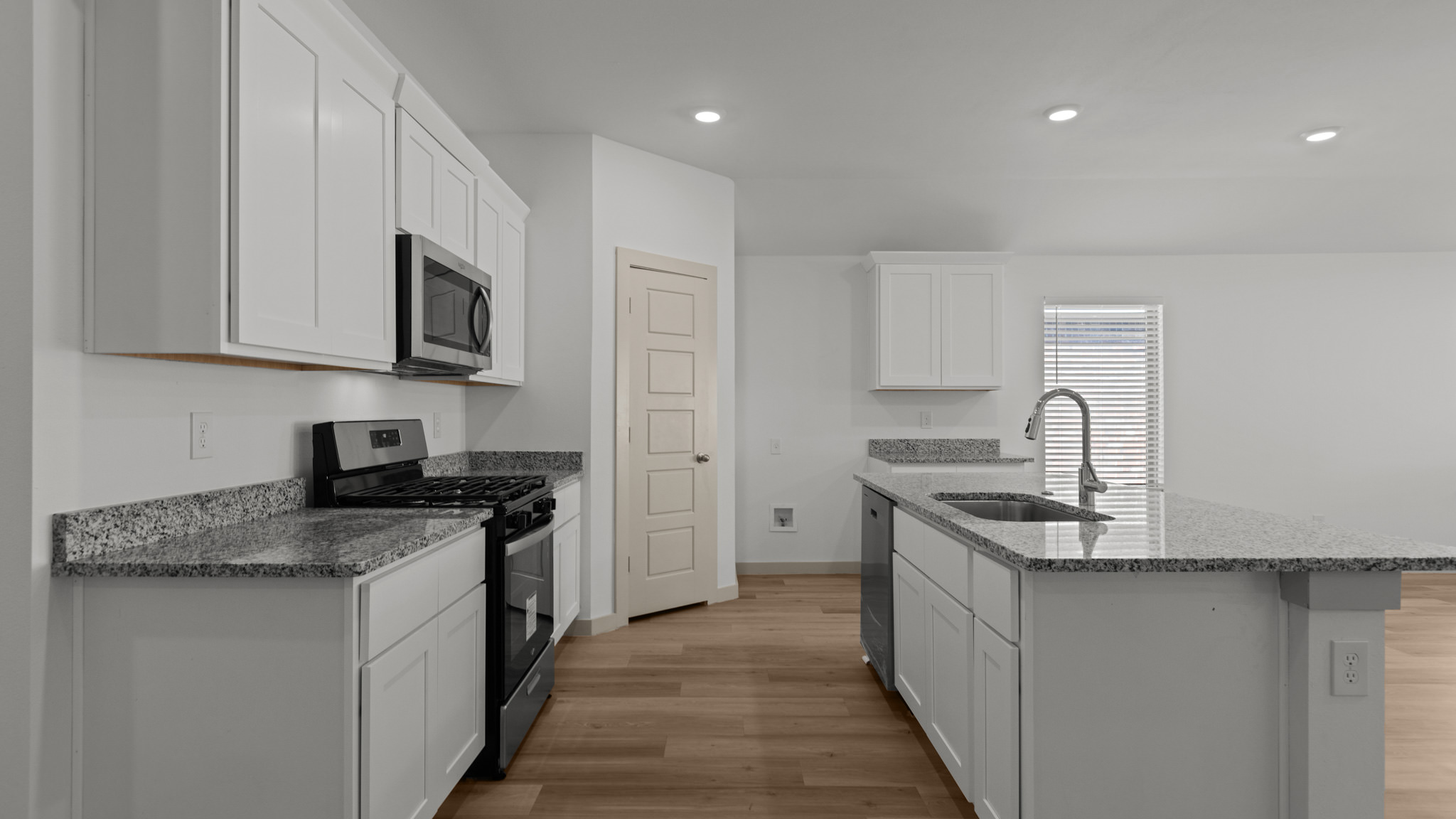 Kitchen with granite counters, white cabinets and stainless steel appliances