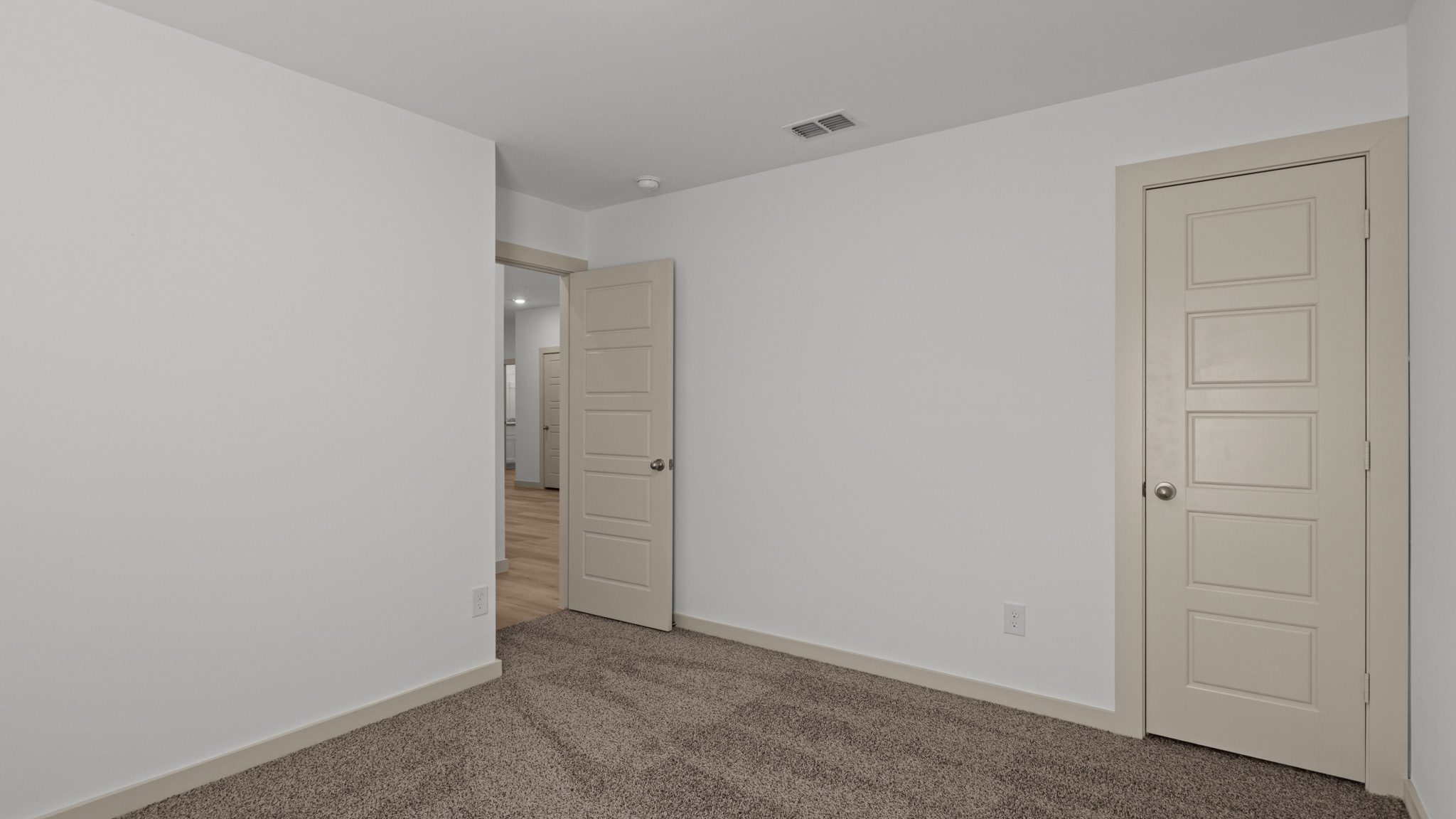 Guest bedroom with plush carpet and spacious closet