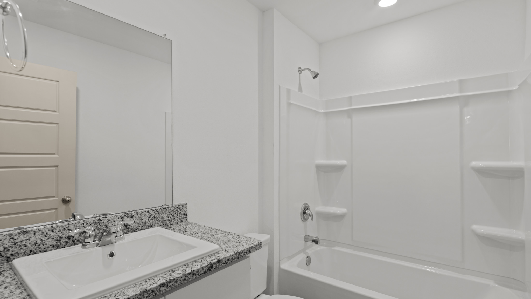 Guest bathroom with single sink, vanity and bath tub shower combo