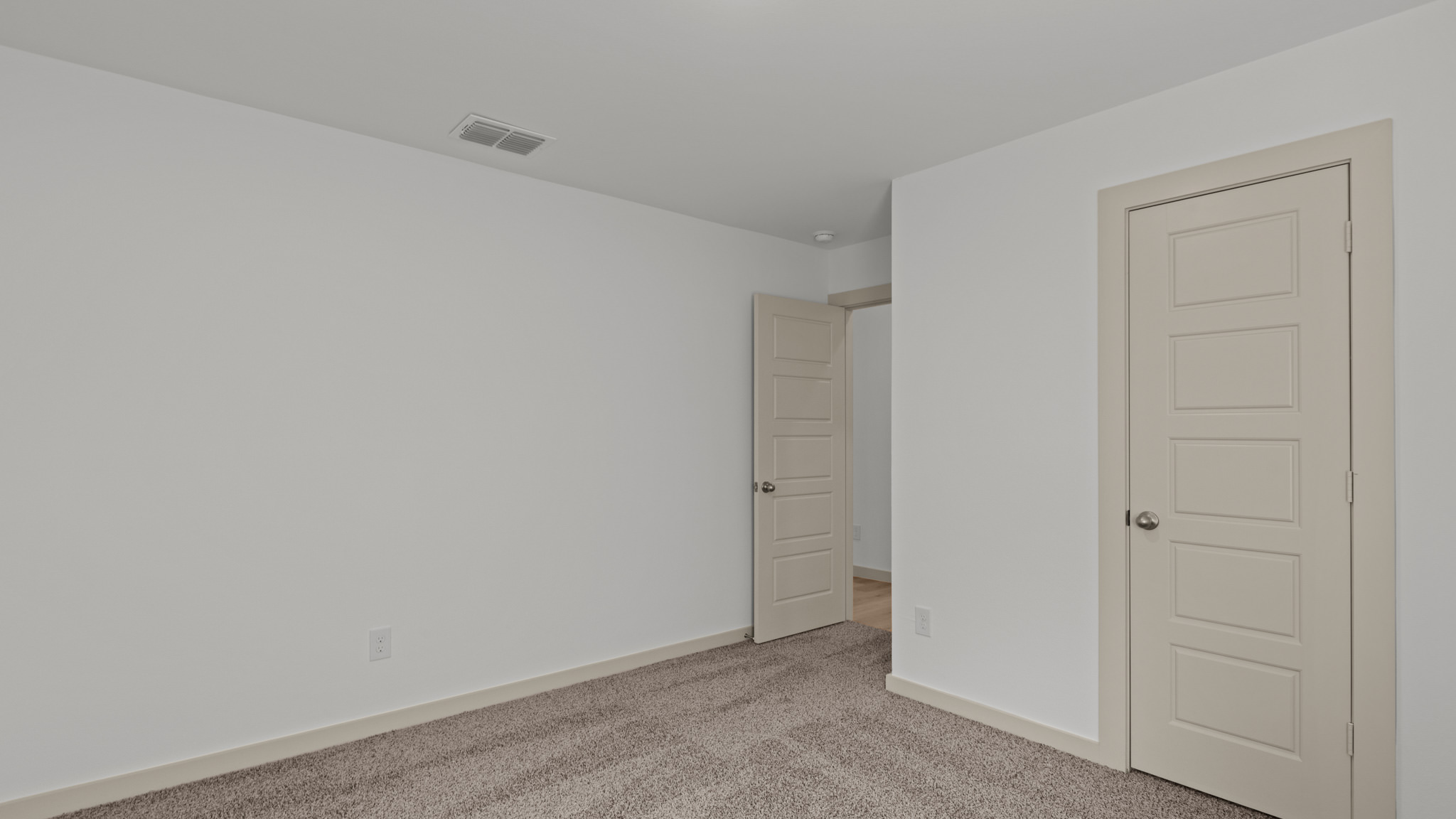 Secondary bedroom with plush carpet and spacious closet
