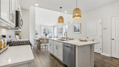 white kitchen with white island and stainless-steel appliances and silver finishes
