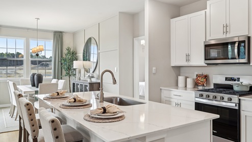 white kitchen with island and stainless-steel appliances