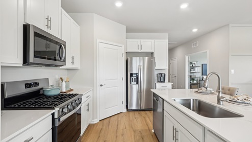 white kitchen with island and stainless-steel appliances