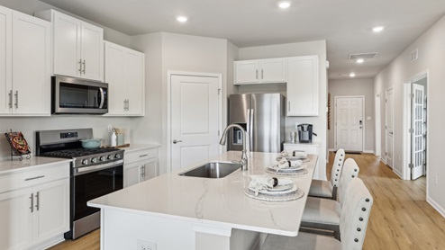 white kitchen with island and stainless-steel appliances