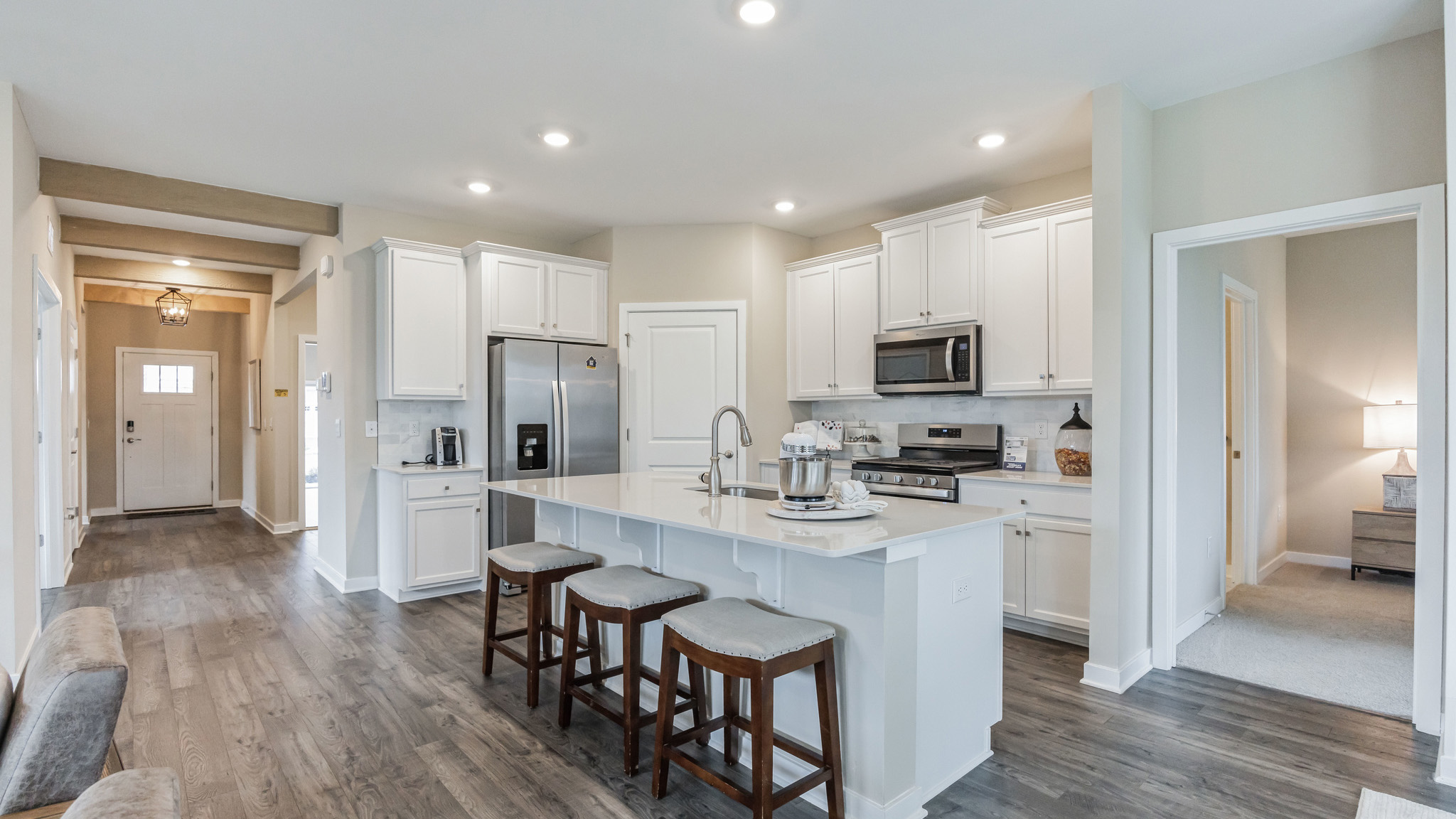 White kitchen with white kitchen island and stainless steel appliances